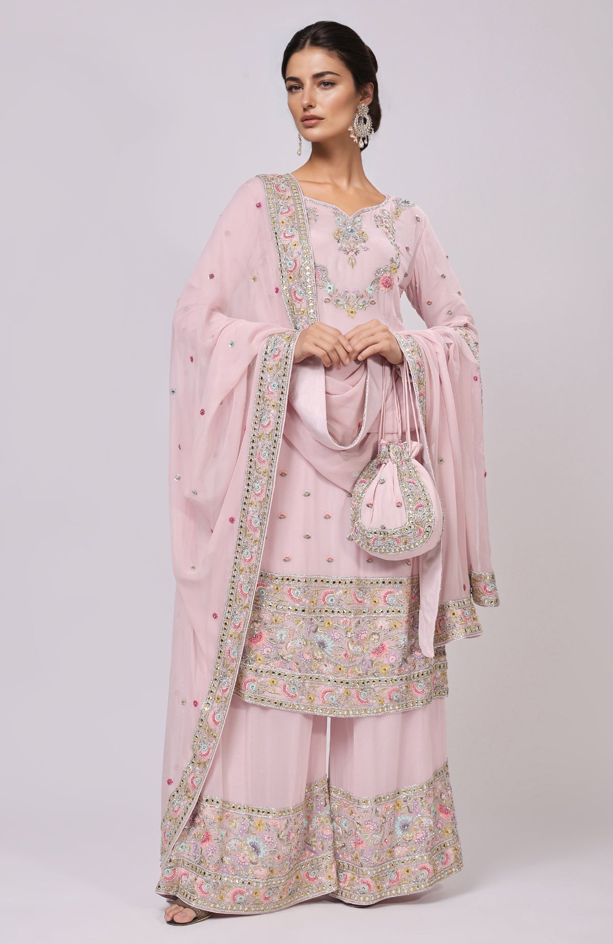 Marshmallow pink sharara set with resham and zardozi embroidery, and a matching potli bag.