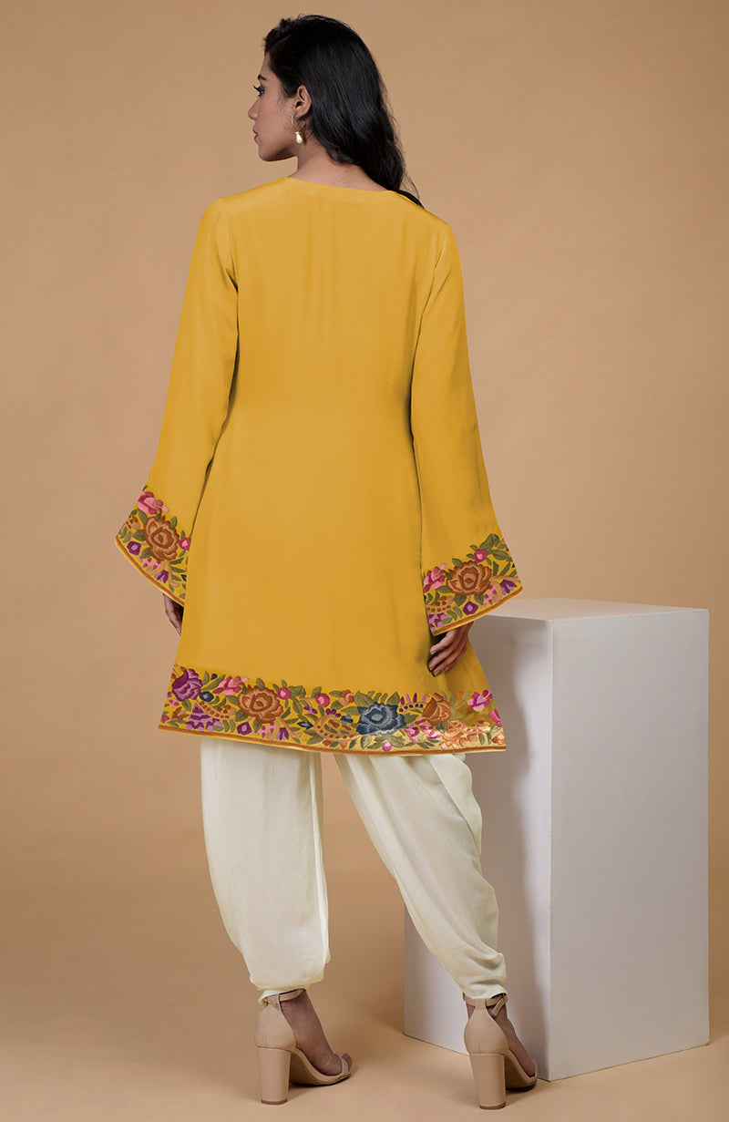 A woman from behind wears a yellow Parsi Gara embroidered kurta with ivory patiala pants.