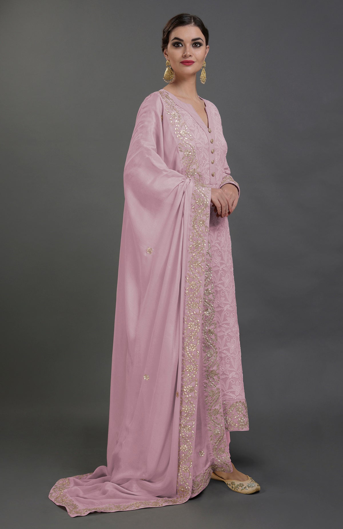 A woman models a lilac chikankari kurta set with gold gota patti embroidery.