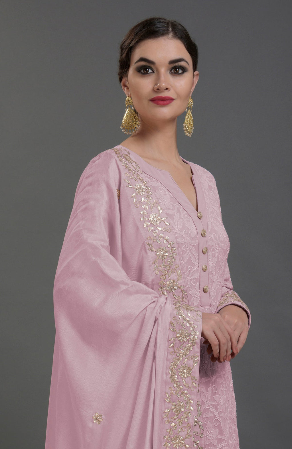 A woman models a lilac chikankari kurta set with gold gota patti embroidery.