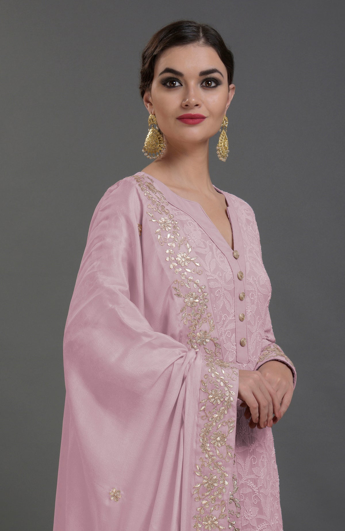 A woman models a lilac chikankari kurta set with gold gota patti embroidery.