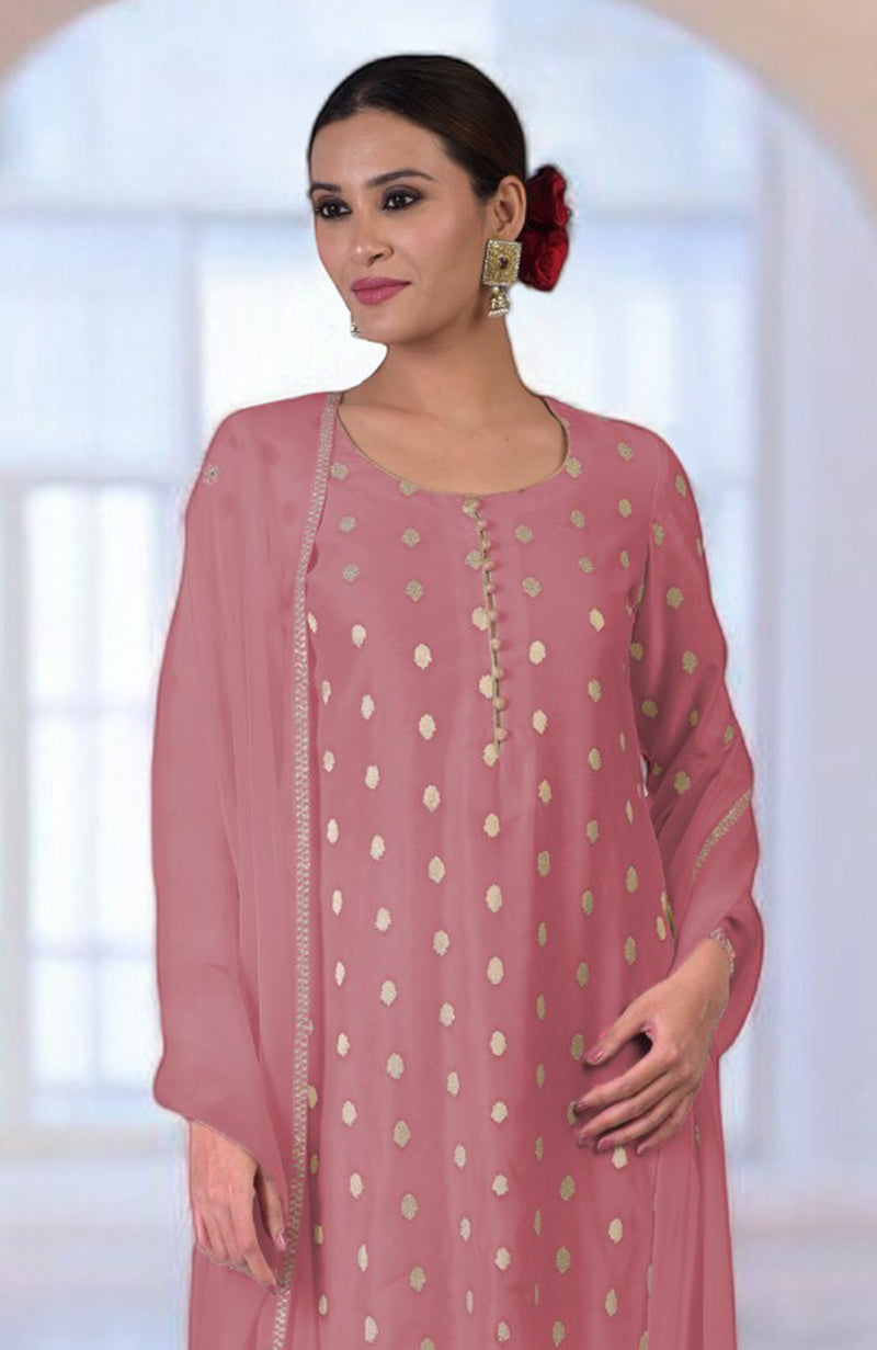 A woman models a withered rose kurta set with gold polka dots and embroidery.