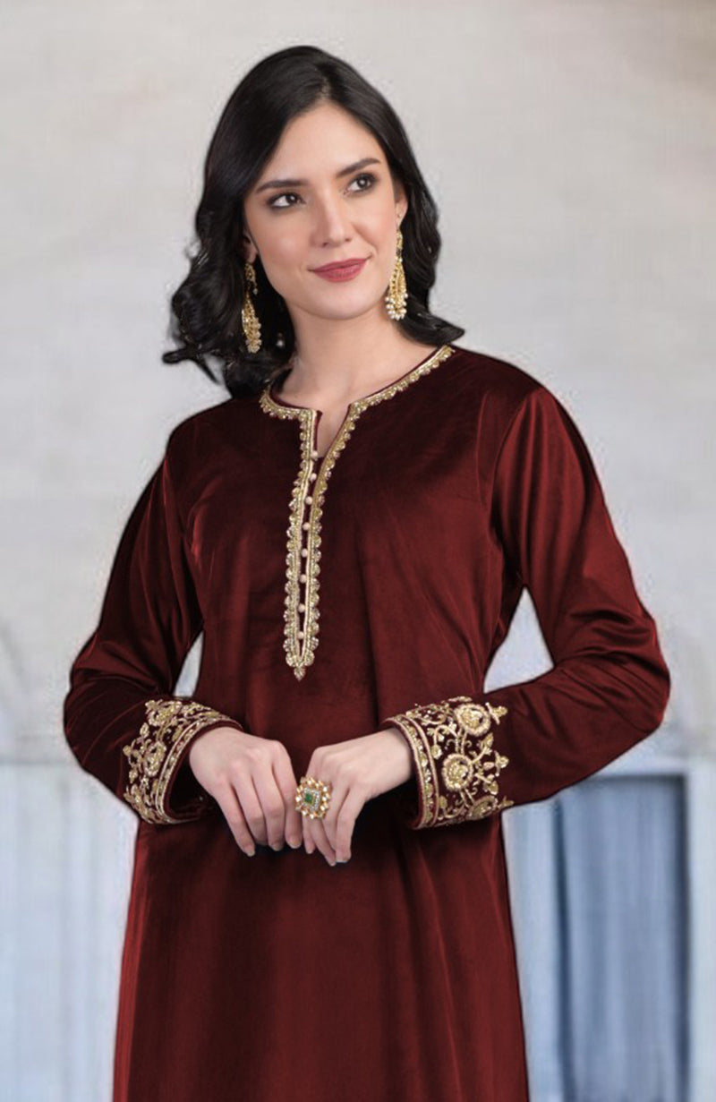 A woman models a maroon velvet kurta with gold zardozi embroidery on the neckline and cuffs.