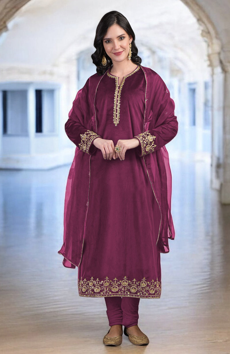 A woman models a maroon kurta set with gold embroidery and a sheer dupatta.