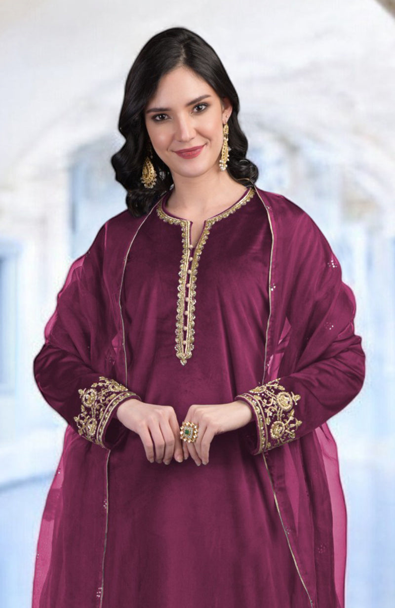 A woman models a peacock pink kurta set with gold zardozi embroidery.