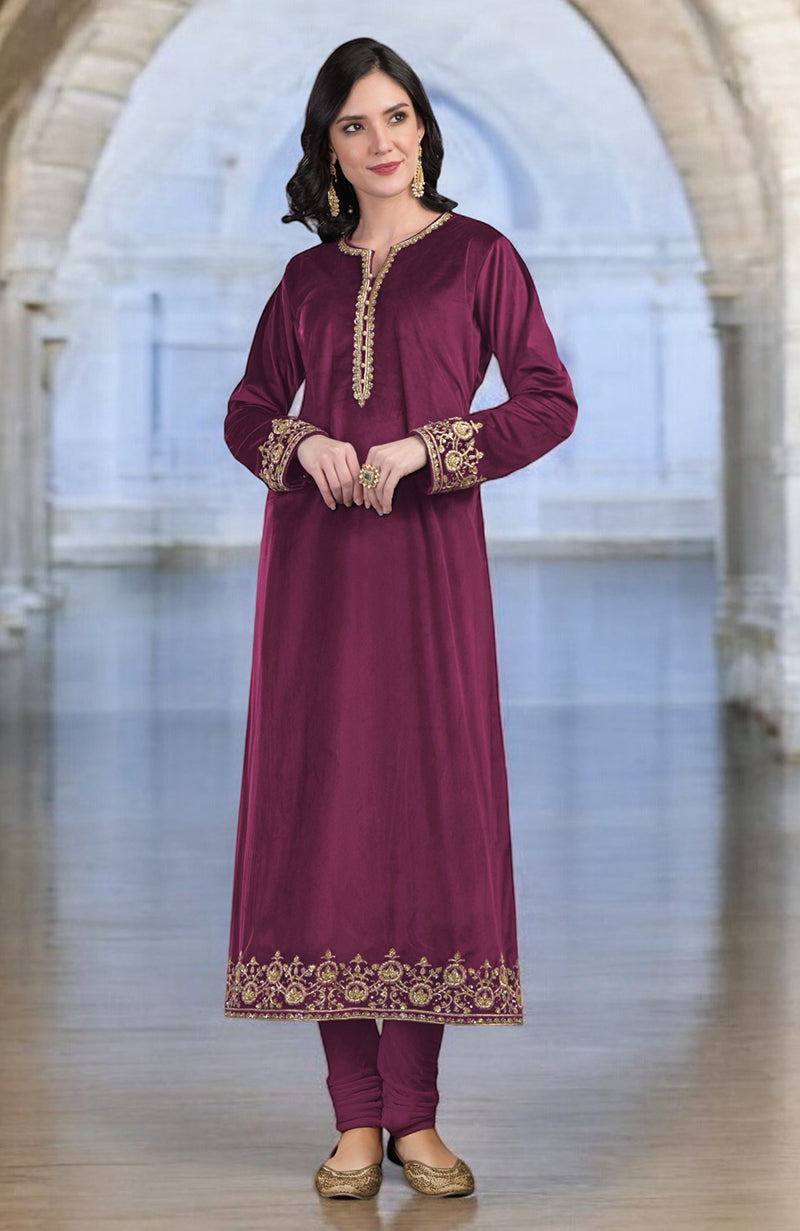 A woman models a maroon velvet kurta set with gold zardozi embroidery.