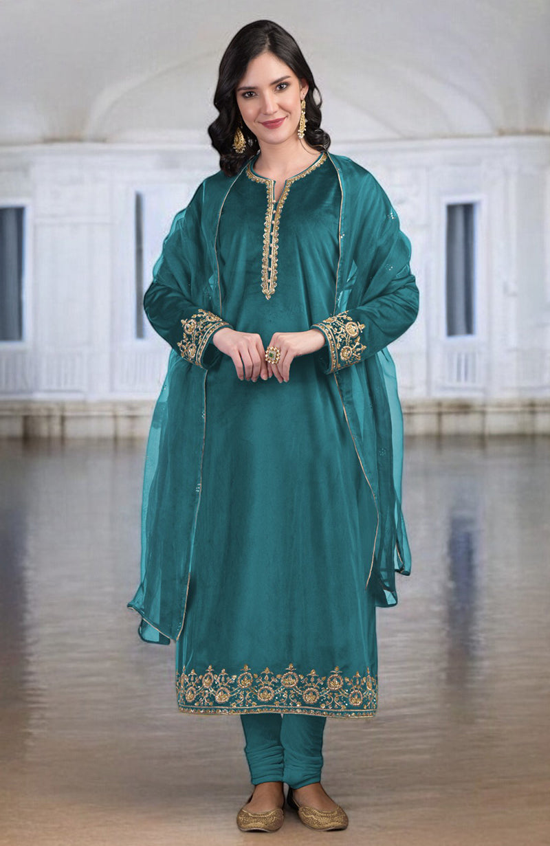 Woman in a teal kurta set with gold embroidery and a sheer dupatta.