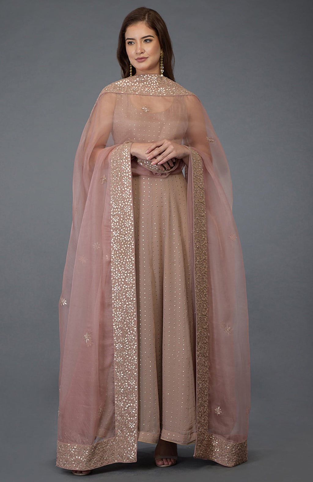 A woman models a dusky pink Anarkali suit with a matching gota patti dupatta.