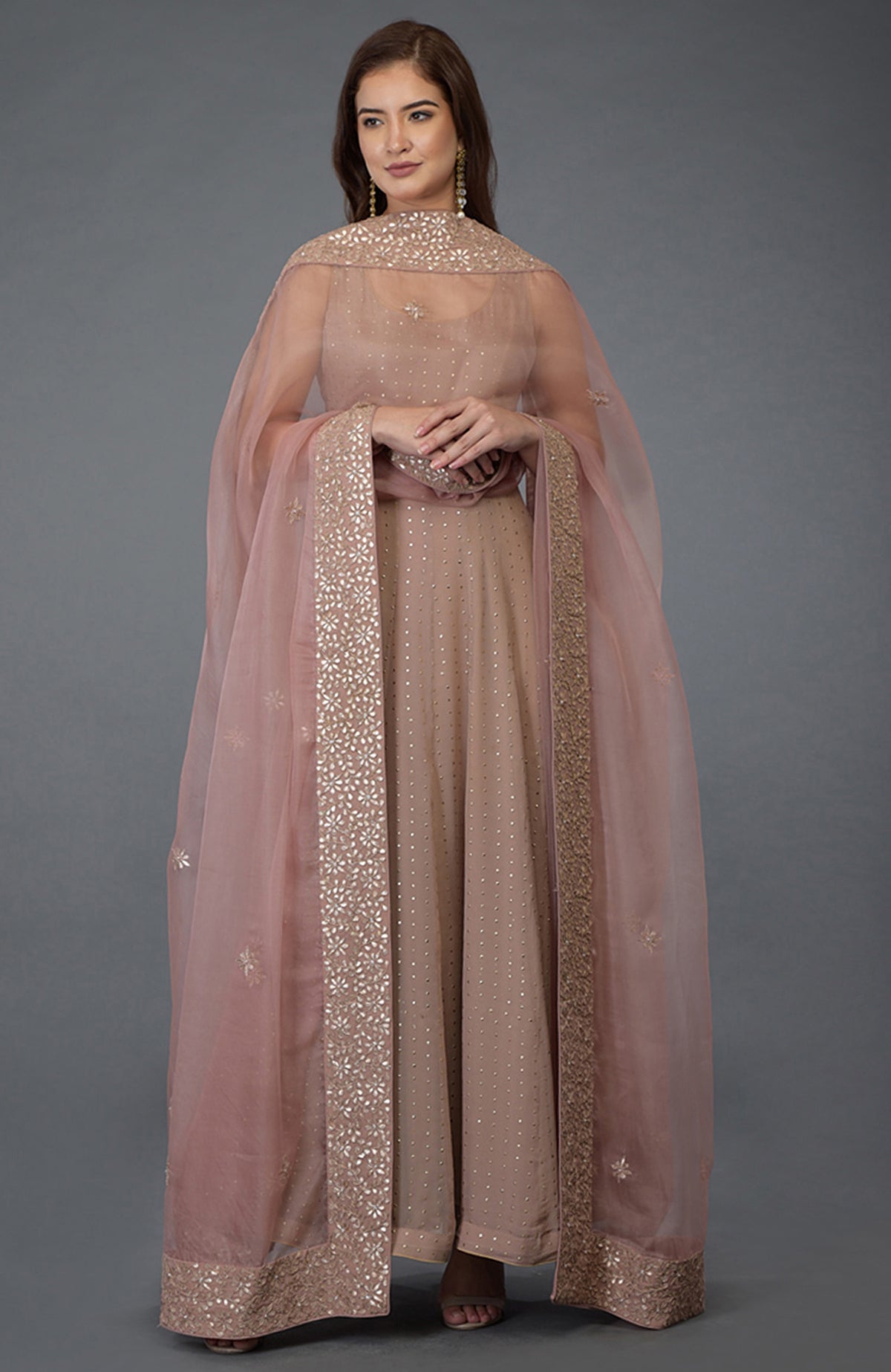A woman models a dusky pink Anarkali suit with a matching gota patti dupatta.