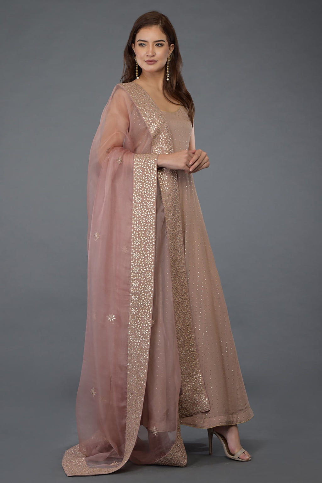 A woman models a dusky pink Anarkali suit with a matching gota patti dupatta.