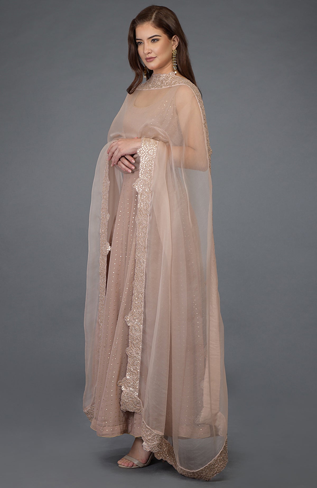 An oyster pink Anarkali suit with a gold dot embossed georgette and gota patti dupatta.