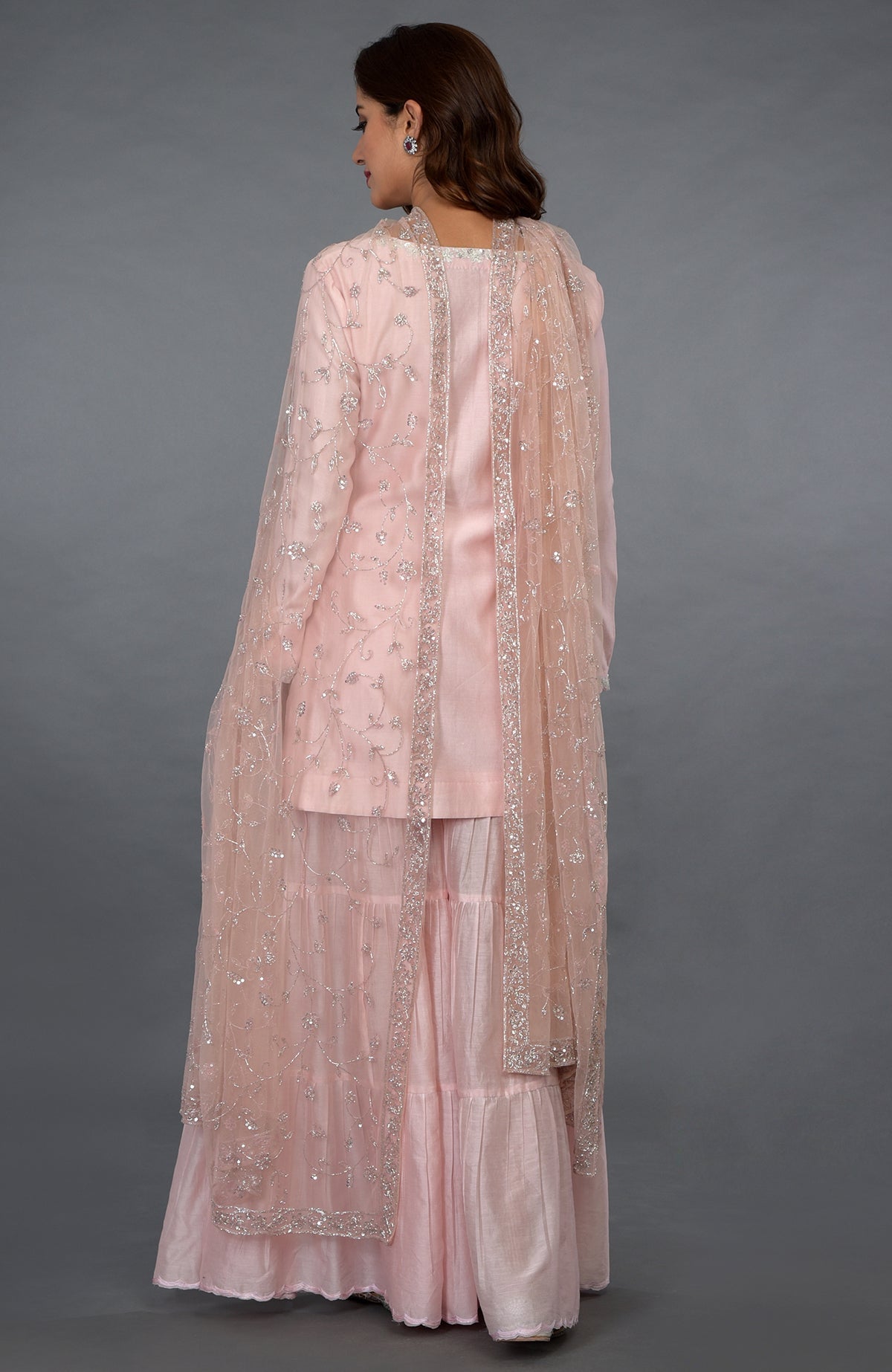 Pink-silver zari, beads, and sequin embroidered gharara suit with a net dupatta.