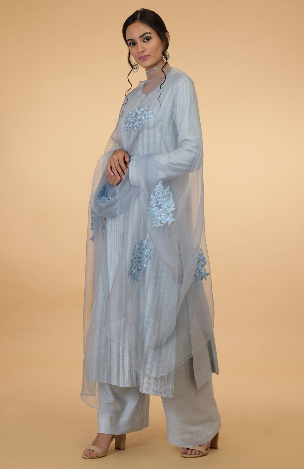 A woman models a powder blue pintuck and Kantha silk kurta set with a dupatta.