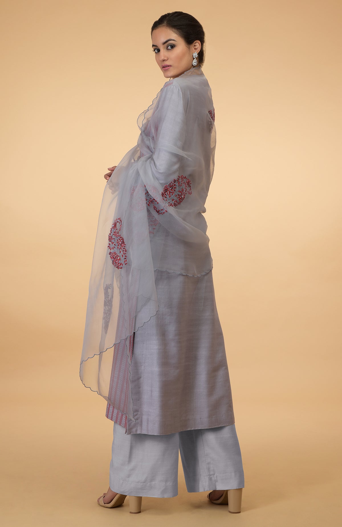 A woman models a grey kurta set with maroon Kantha embroidery and an organza dupatta.