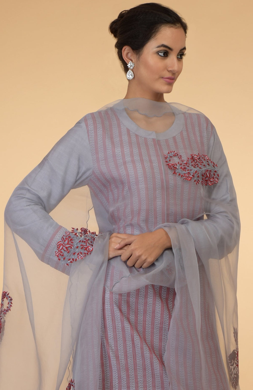 A woman models a grey and maroon Kantha embroidered kurta set with a dupatta.