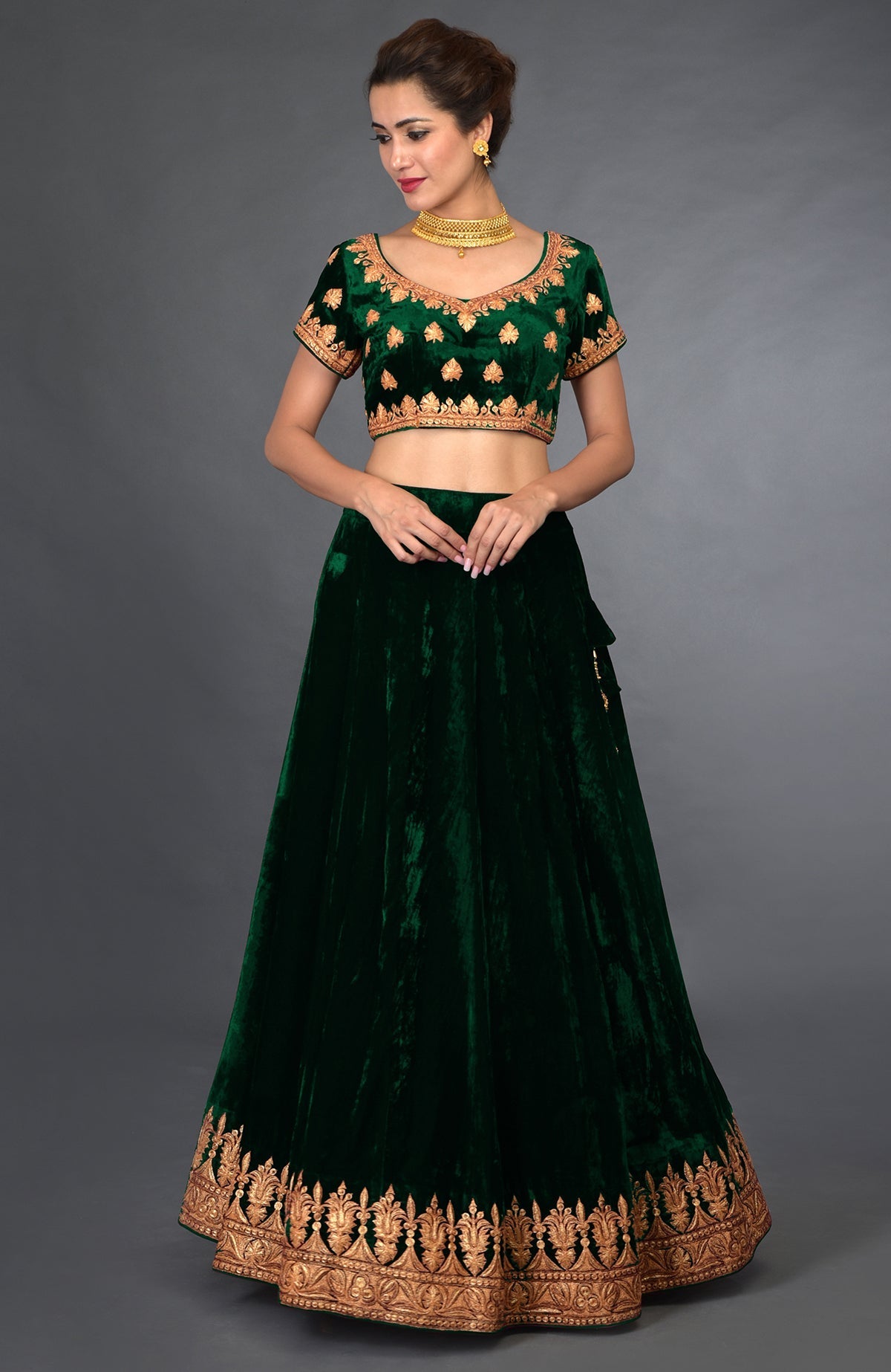 Emerald green velvet lehenga outfit with gold tilla embroidery.