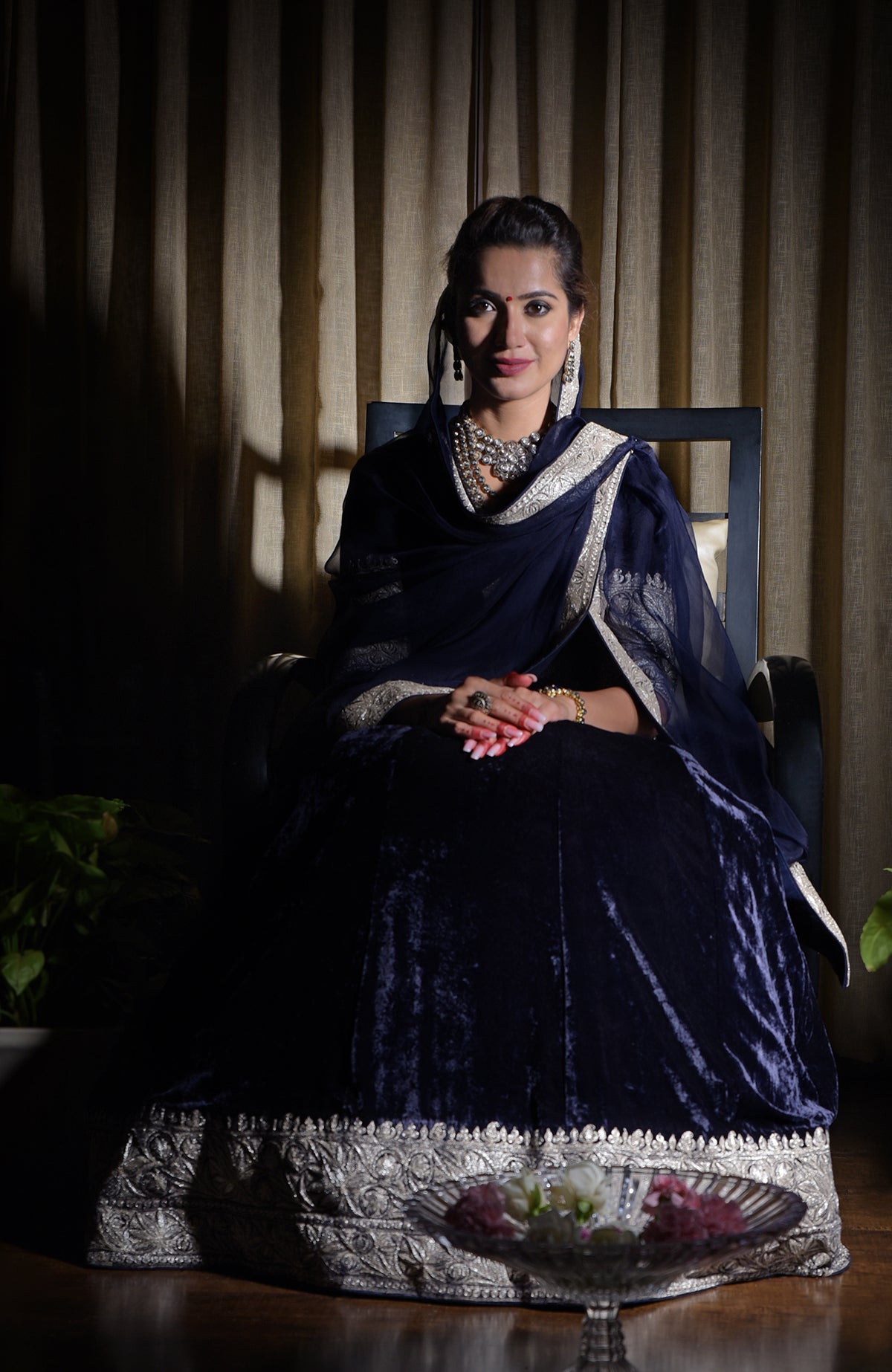 Woman in a midnight blue Kashmiri Tilla embroidered lehenga outfit.
