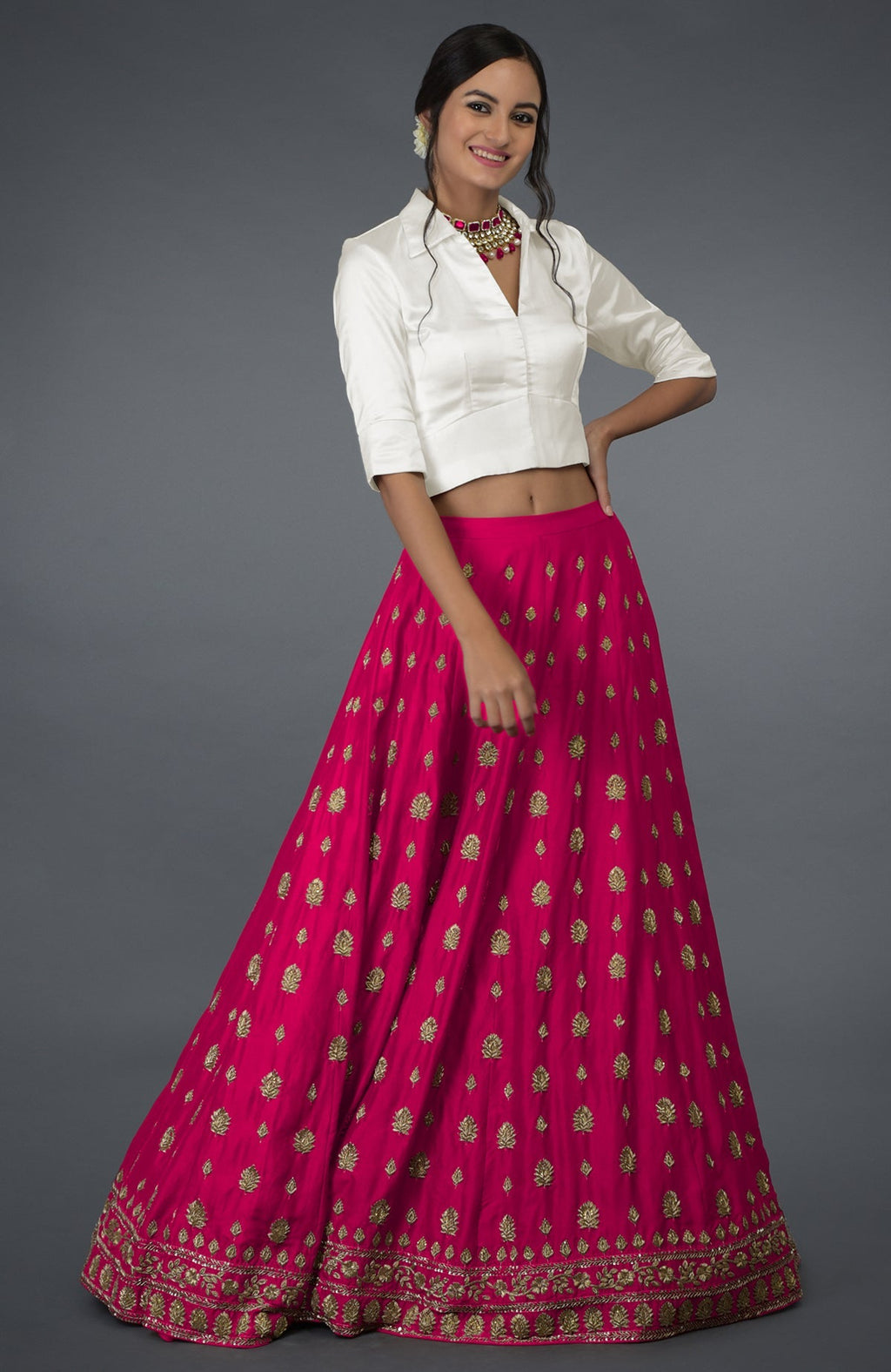 A woman models a berry gloss zardozi and crystal hand-embroidered skirt with a blouse.