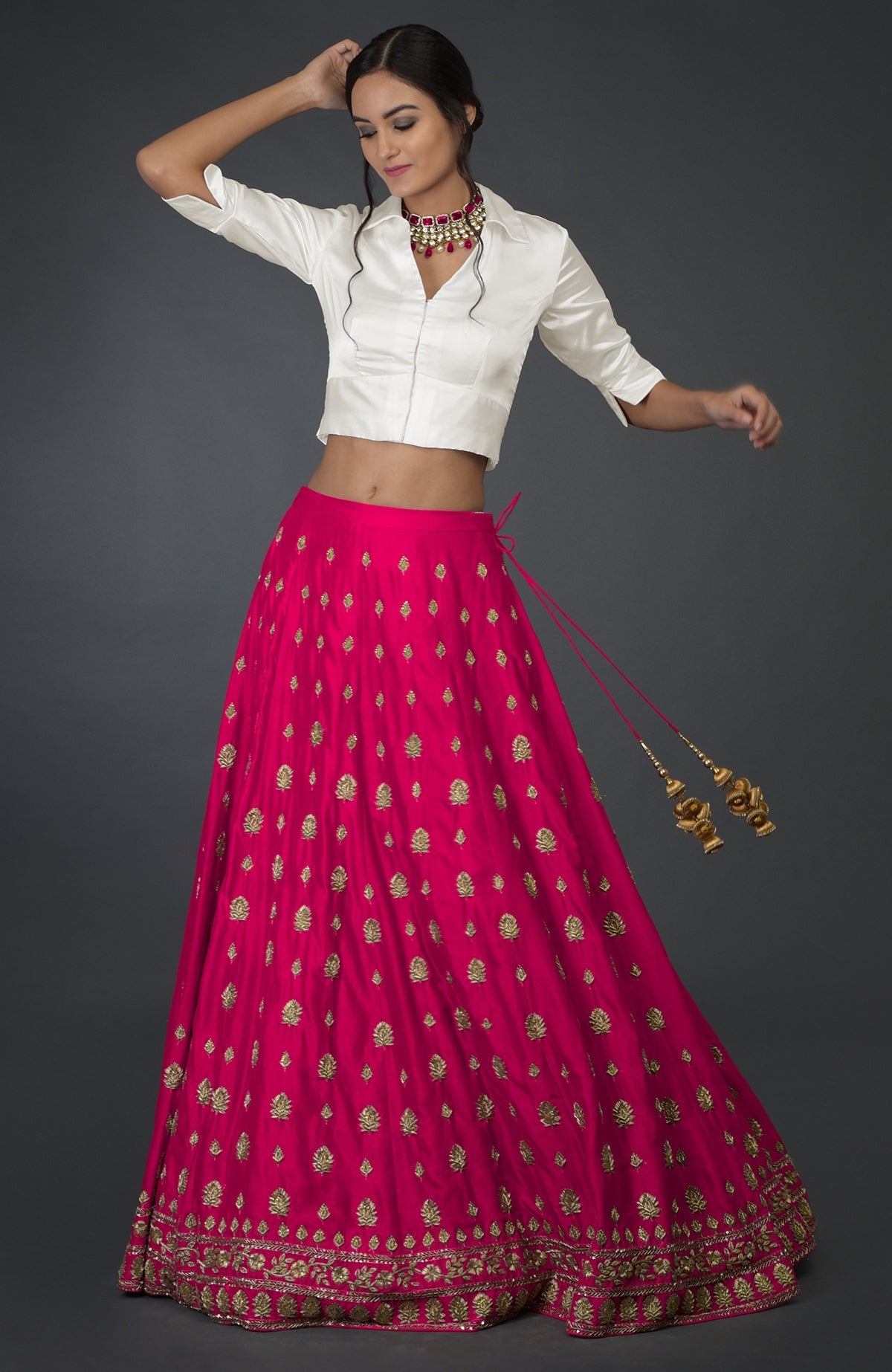 A woman models a berry gloss zardozi and crystal hand-embroidered skirt with an ivory blouse.