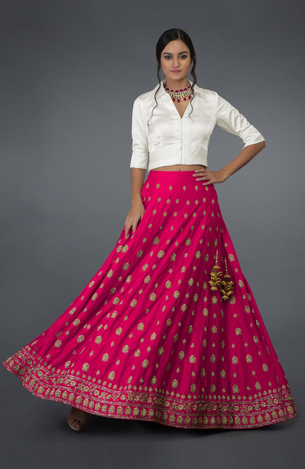 A woman models a berry gloss pure silk skirt with gold zardozi and crystal embroidery.