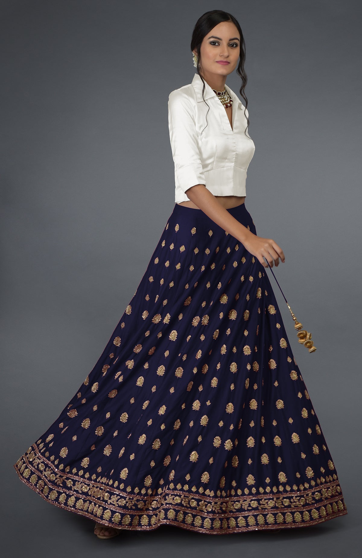 An eclipse blue zardozi and crystal hand-embroidered skirt with an ivory satin silk blouse.