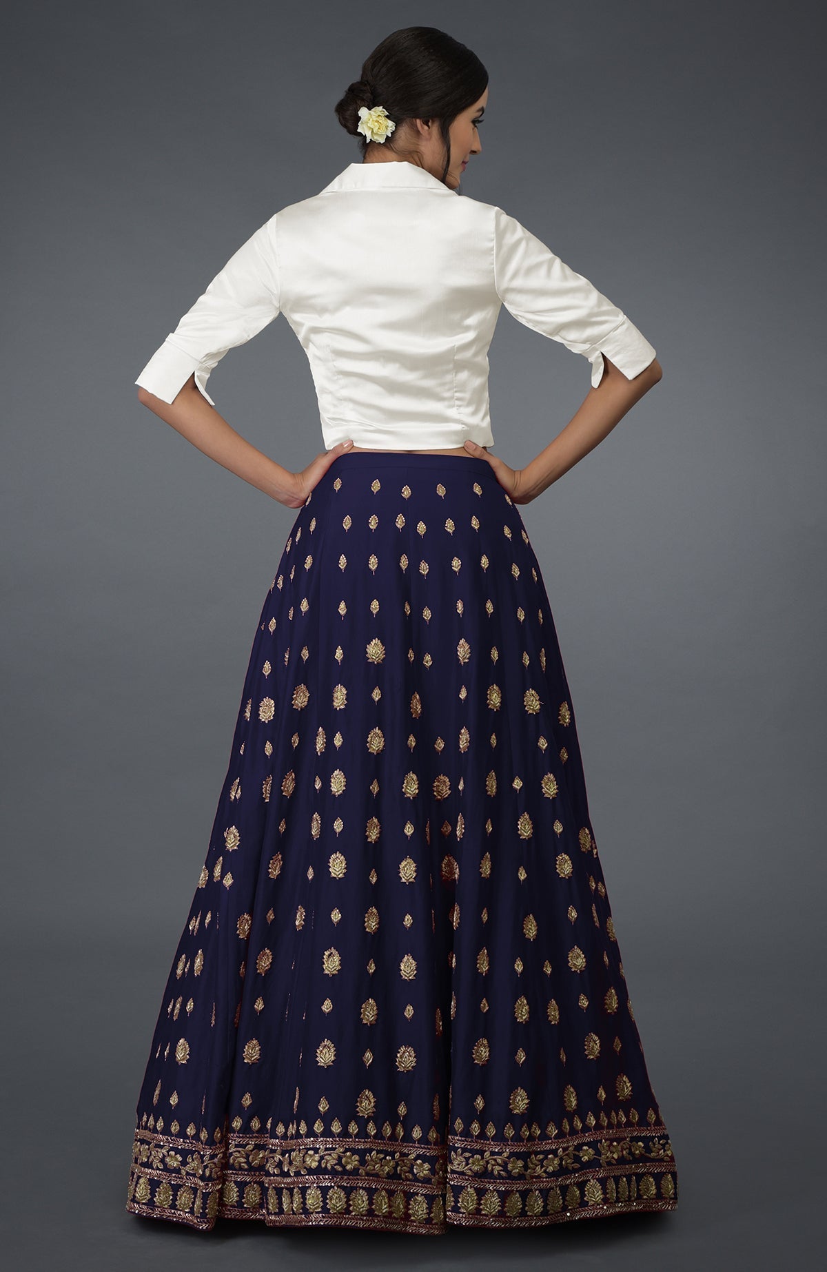 A woman models an eclipse blue silk skirt with gold zardozi and crystal embroidery.