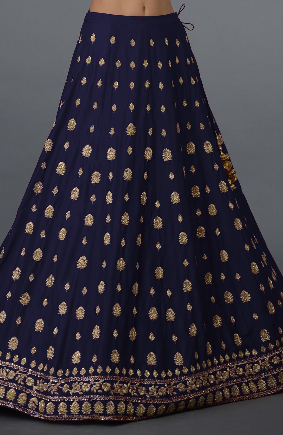 An eclipse blue skirt with gold zardozi and crystal hand embroidery.