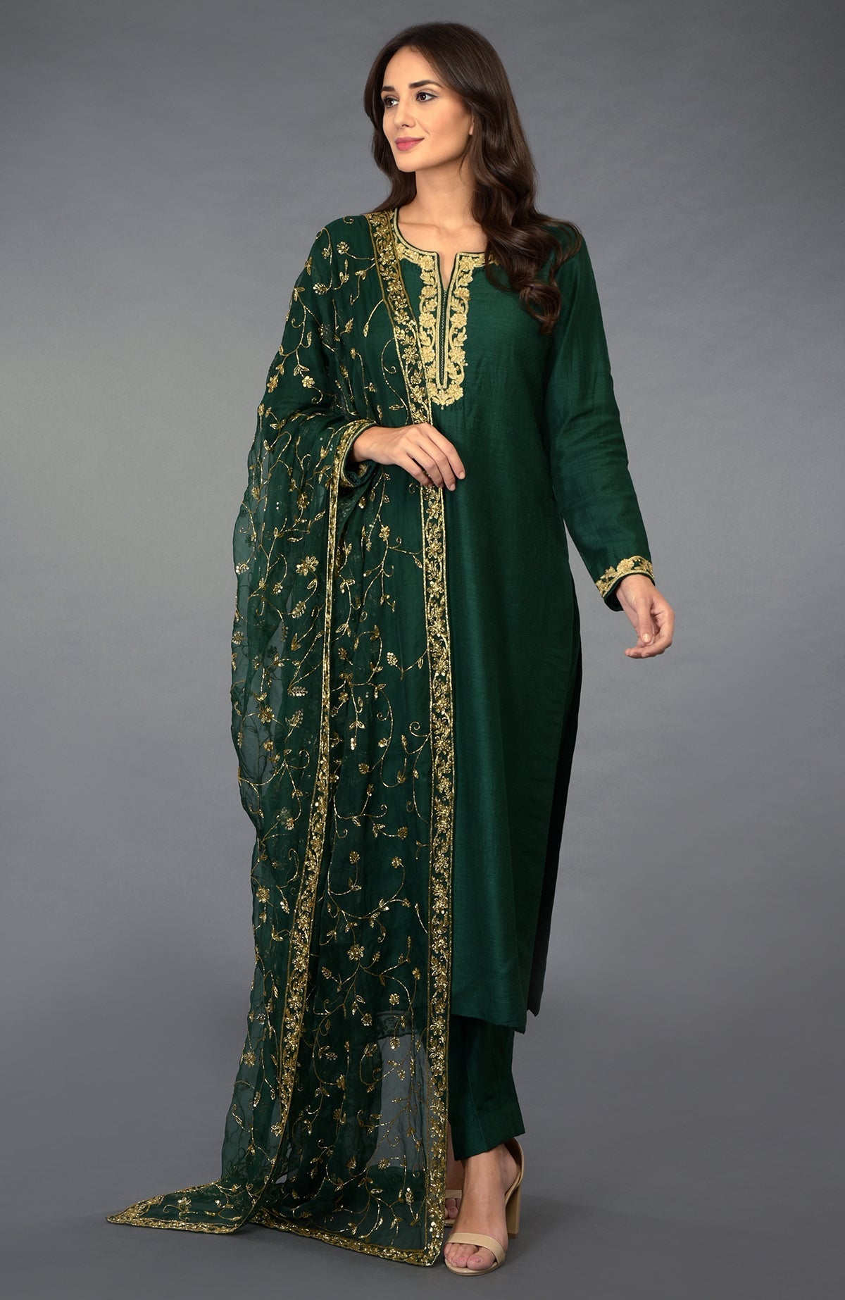 Emerald green suit with gold zari, beads, and sequin embroidery, paired with a matching dupatta.