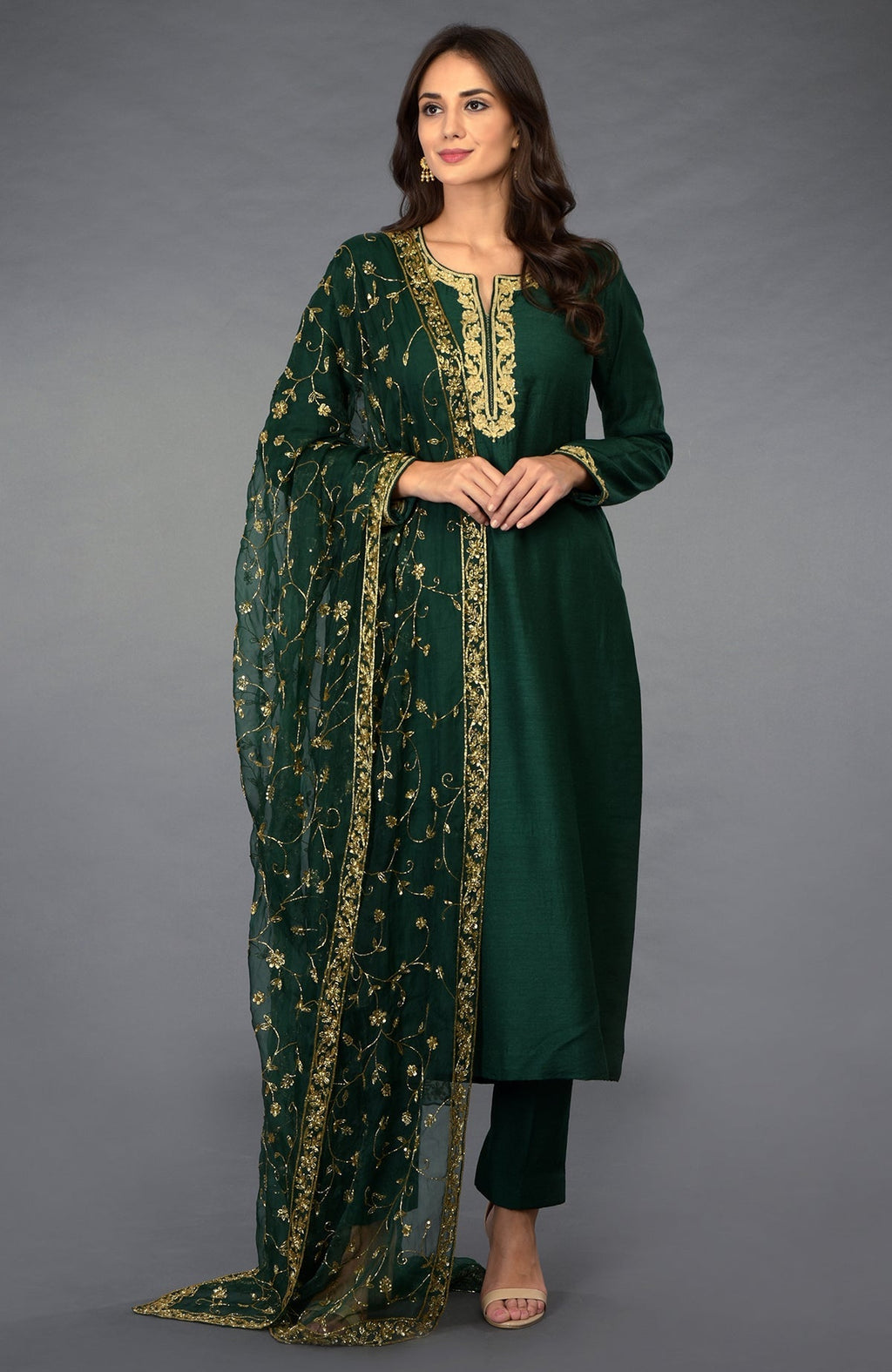 Emerald green suit with gold zari, beads, and sequin embroidery.