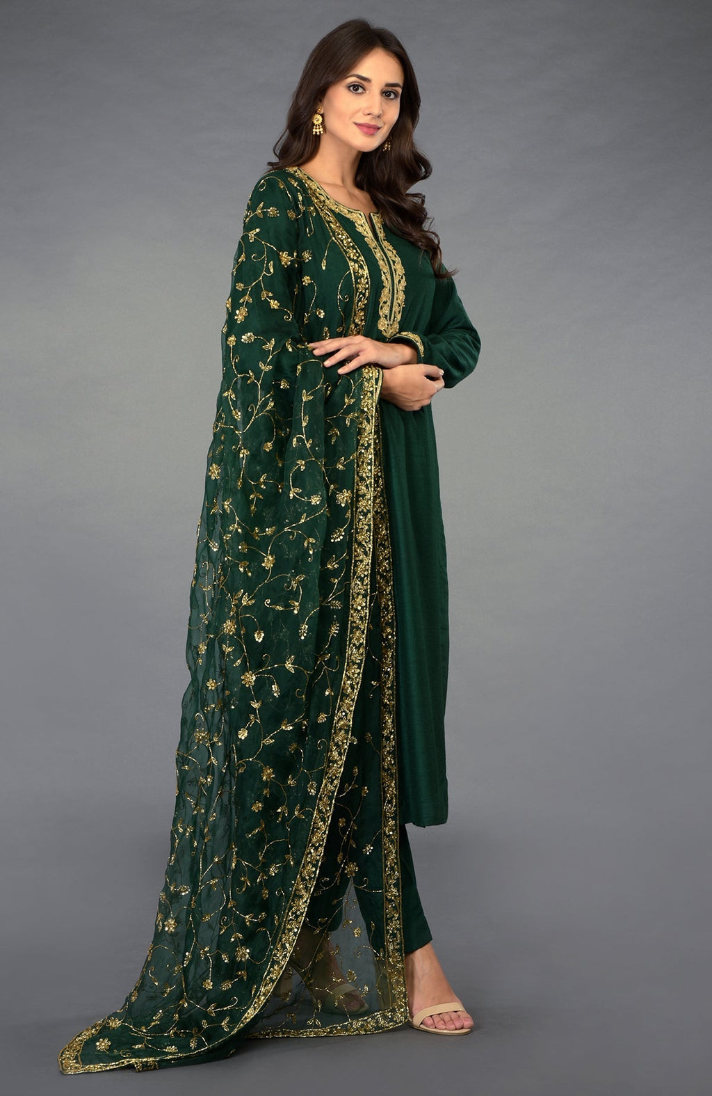 Emerald green suit with gold zari, sequin, and crystal embroidery, paired with a matching dupatta.