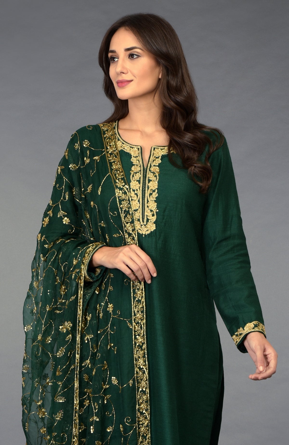Emerald green suit with gold zari, beads, and sequin embroidery, paired with a matching dupatta.