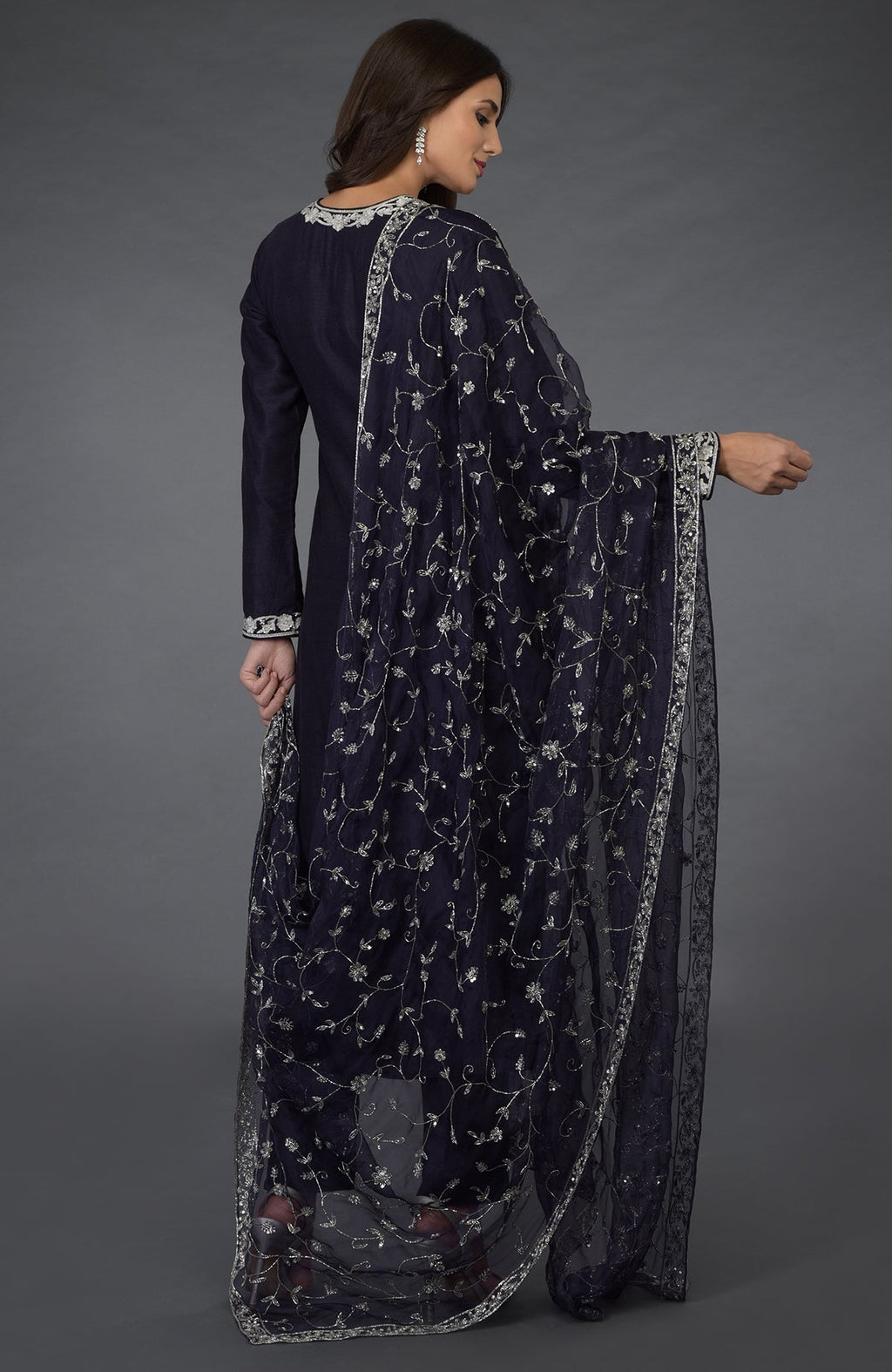 A woman models an eclipse blue suit with silver zari, beads, and sequin embroidery.