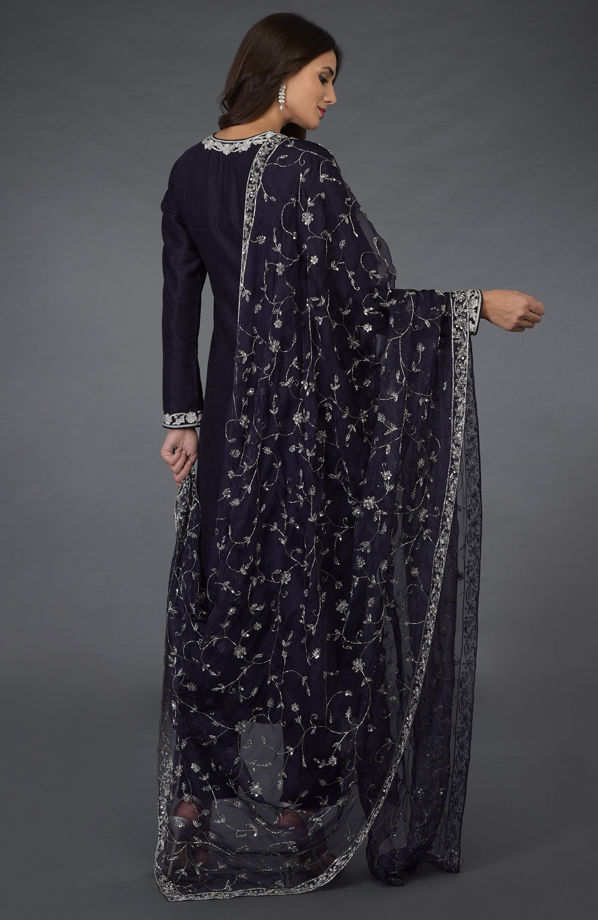 A woman models an eclipse blue suit with silver zari, beads, and sequin embroidery.