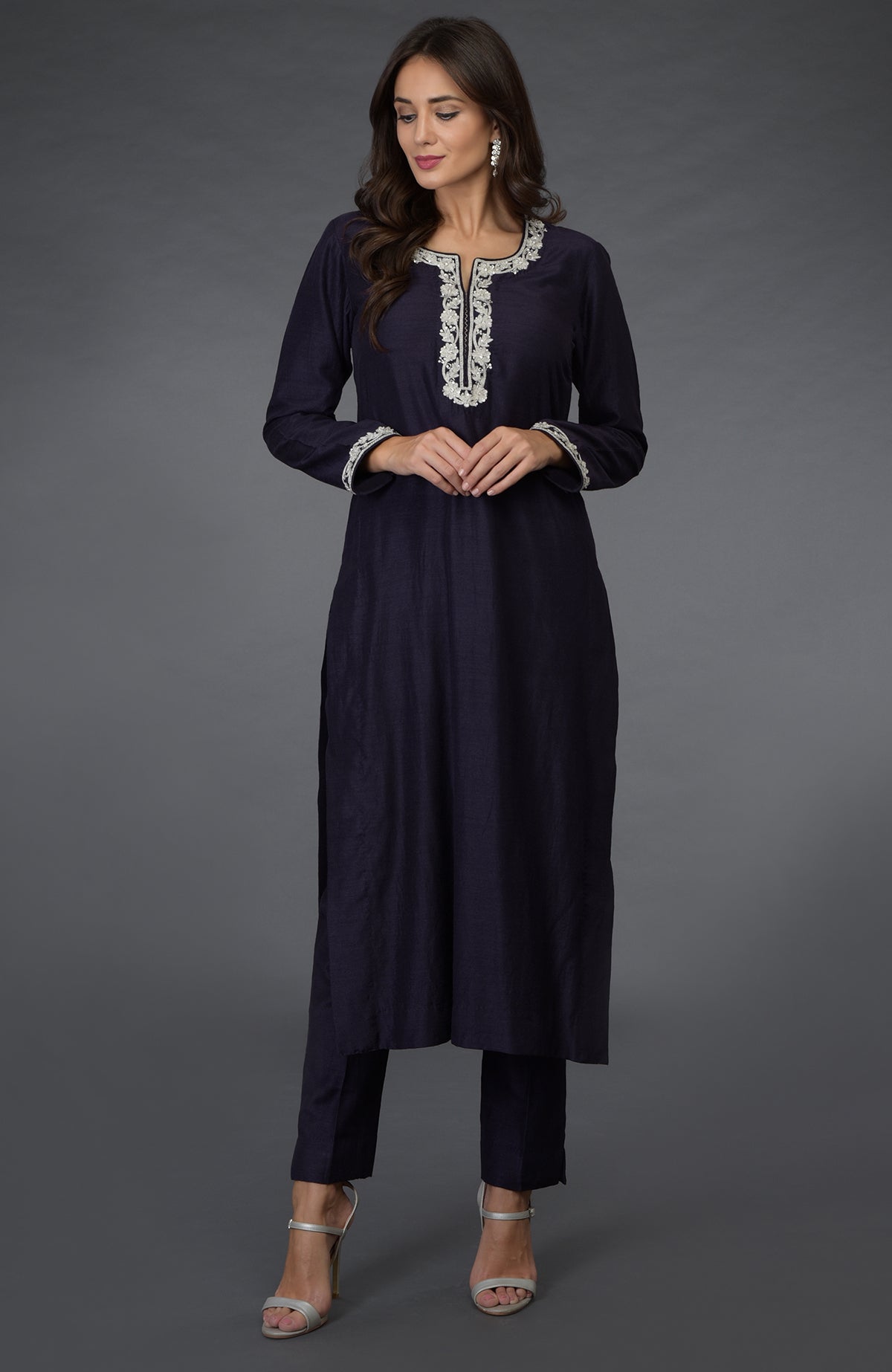 A woman models an eclipse blue suit with silver zari, beads, and sequin embroidery.