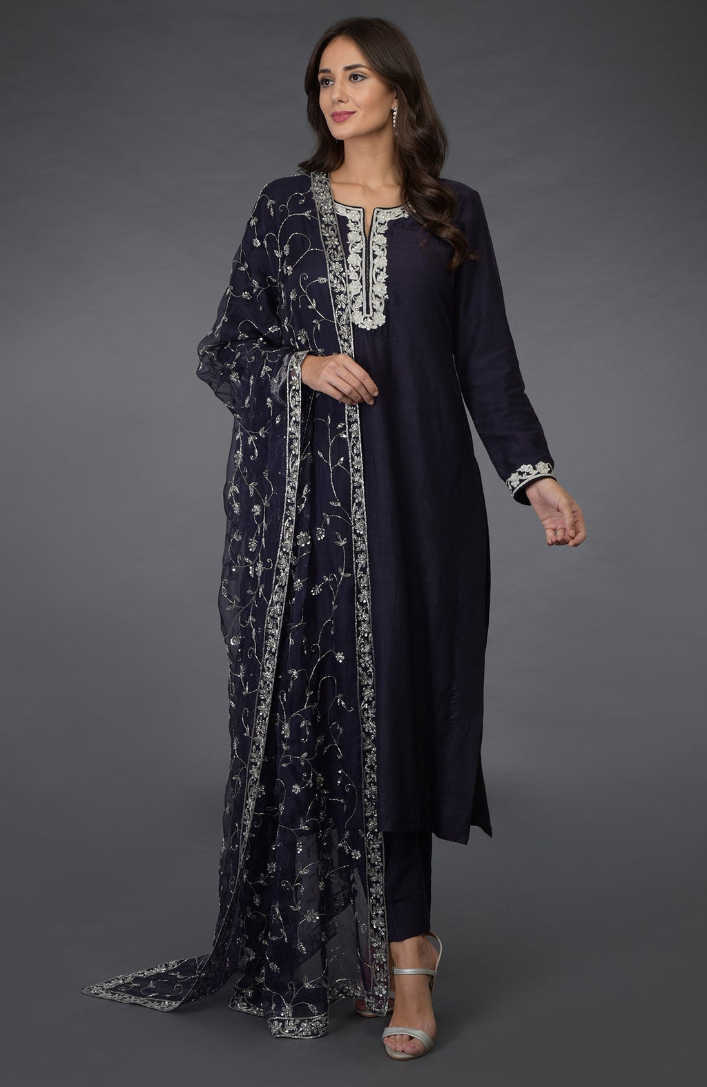 An eclipse blue suit with silver zari, beads, and sequin embroidery.