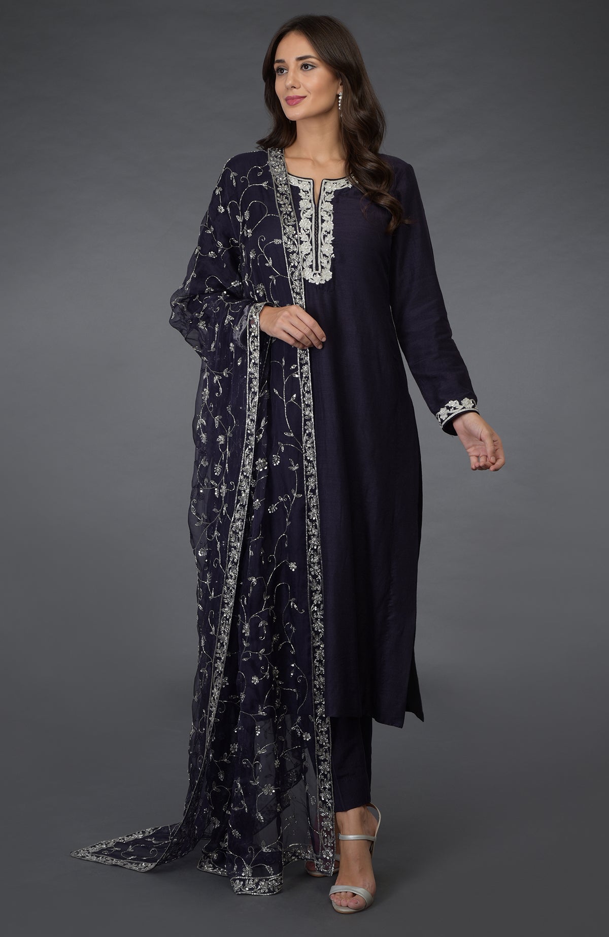 An eclipse blue suit with silver zari, beads, and sequin embroidery.