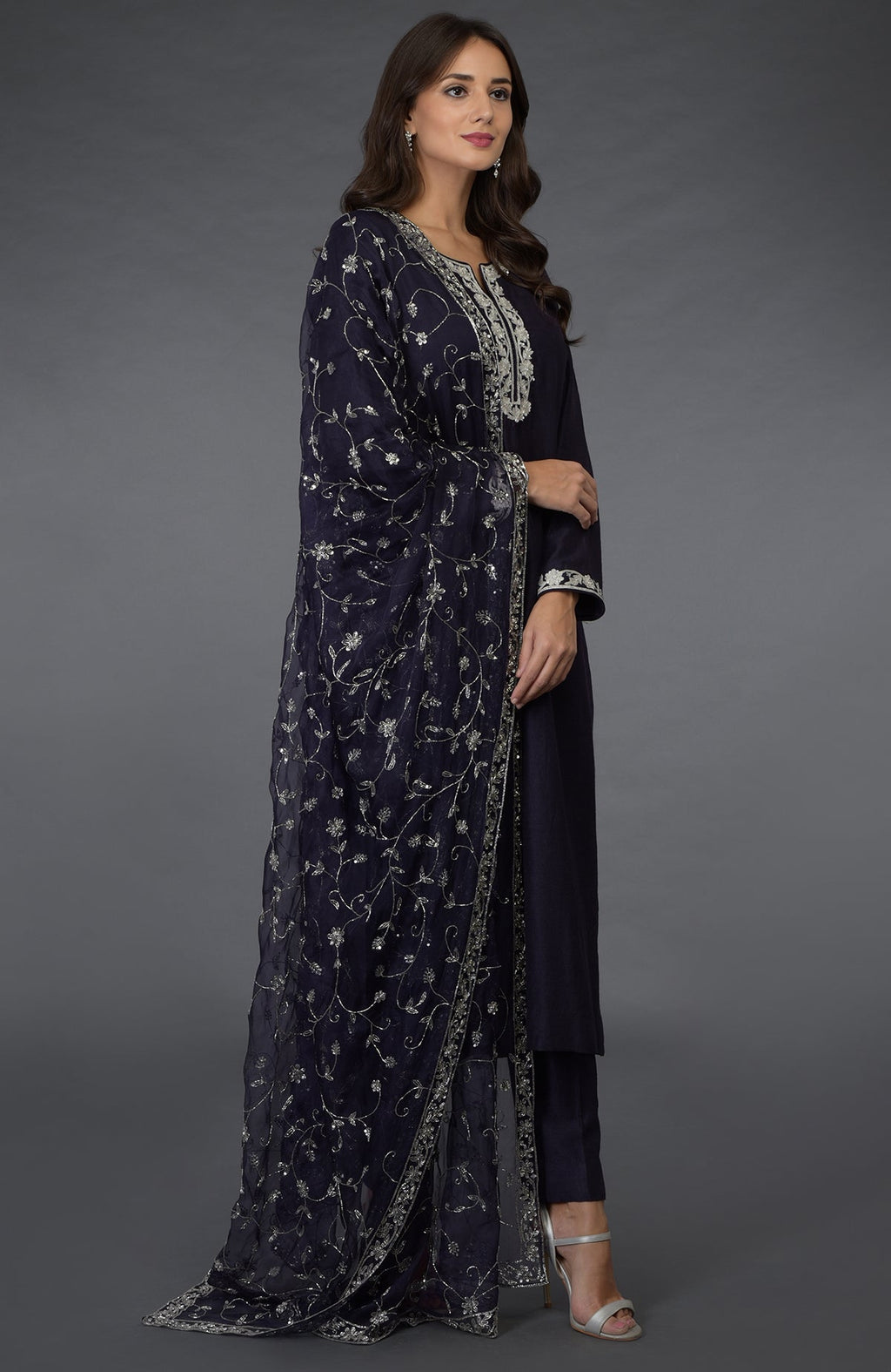 A woman models an eclipse blue suit with silver zari, beads, and sequin embroidery.