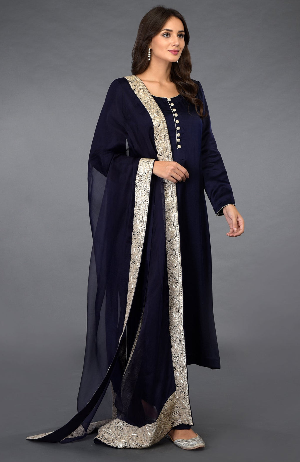 A woman models a midnight blue salwar pants suit with silver tilla embroidery.