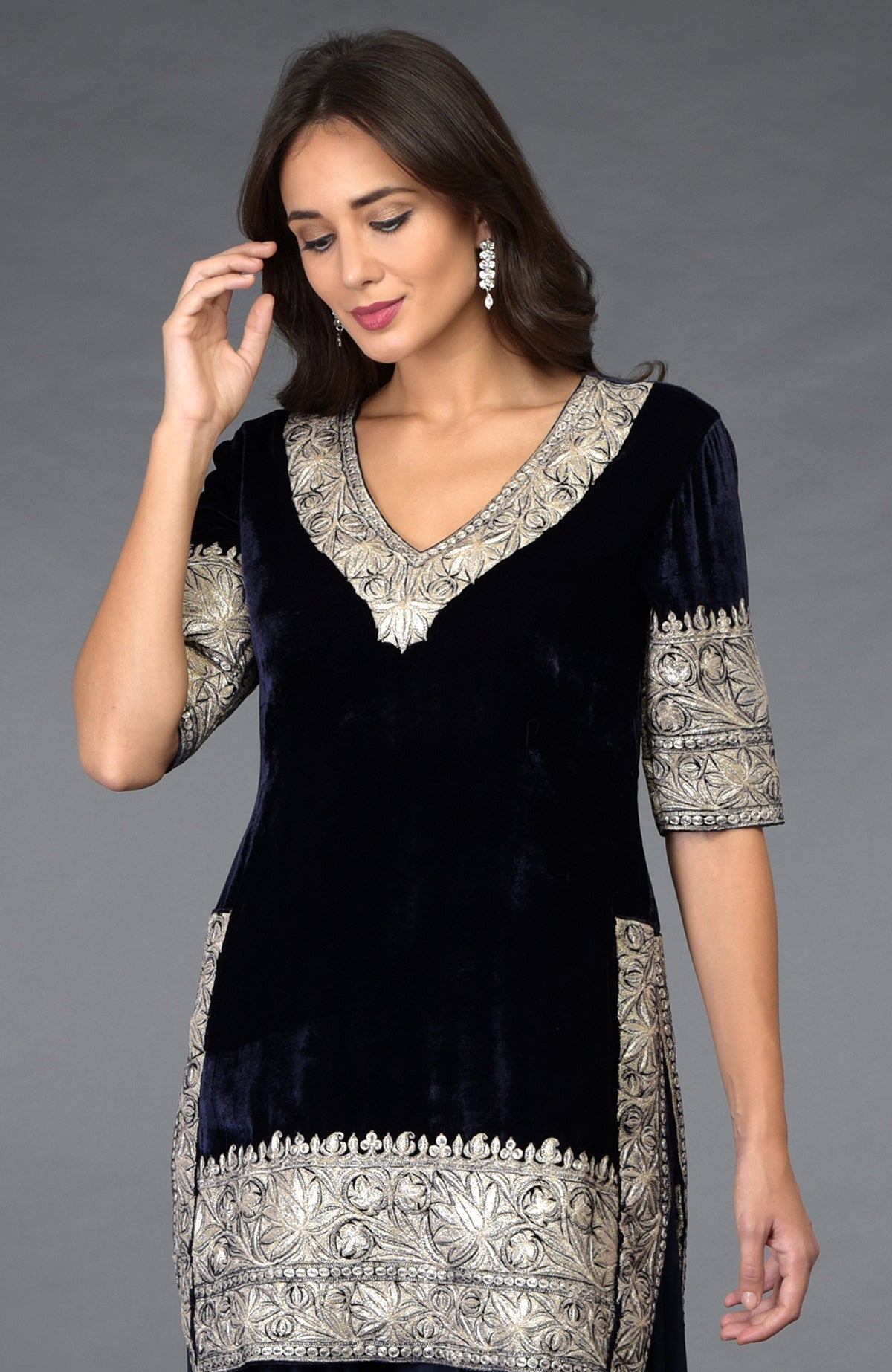 A woman models a midnight blue velvet tunic with silver Kashmiri Tilla embroidery.