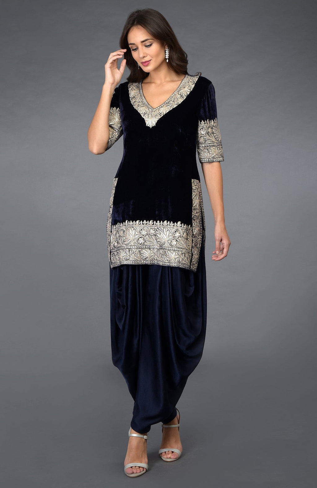 A woman models a midnight blue velvet dhoti pants suit with silver tilla embroidery.