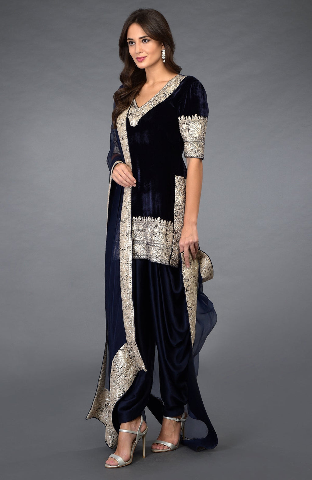 A woman models a midnight blue velvet dhoti pants suit with silver embroidery.