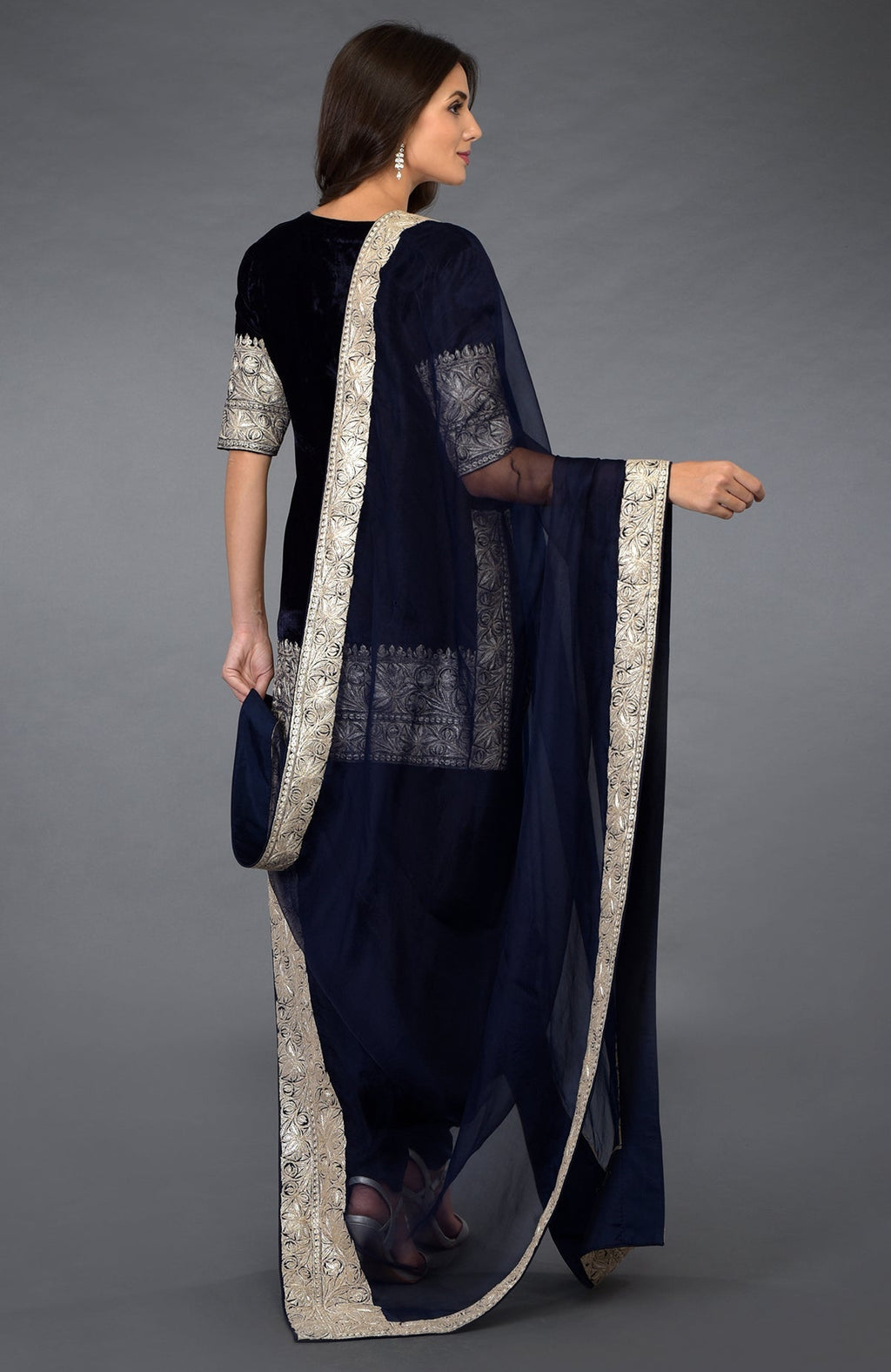 A woman models a midnight blue Kashmiri Tilla embroidered dhoti pants suit.