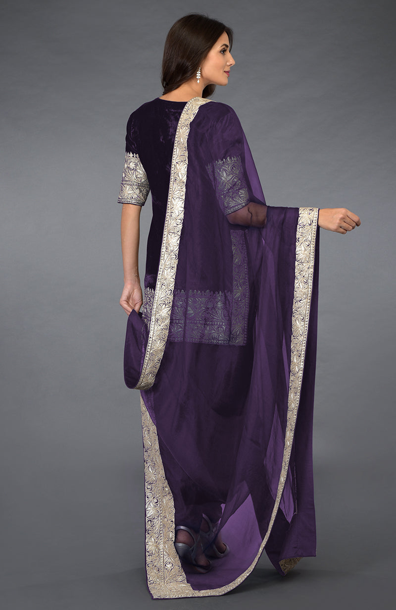 A woman models a mulled grape Kashmiri tilla embroidered dhoti pants suit.