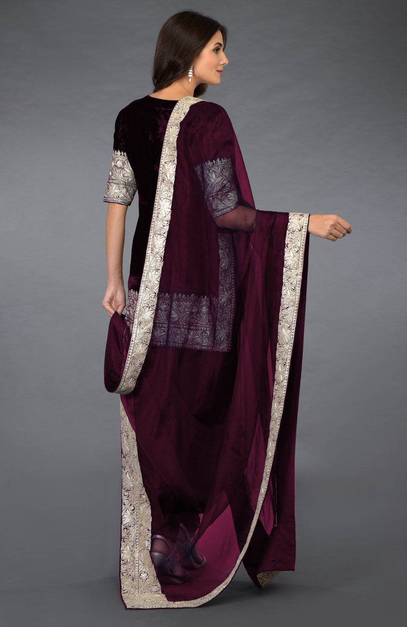 A woman models a burgundy velvet dhoti pants suit with silver tilla embroidery.
