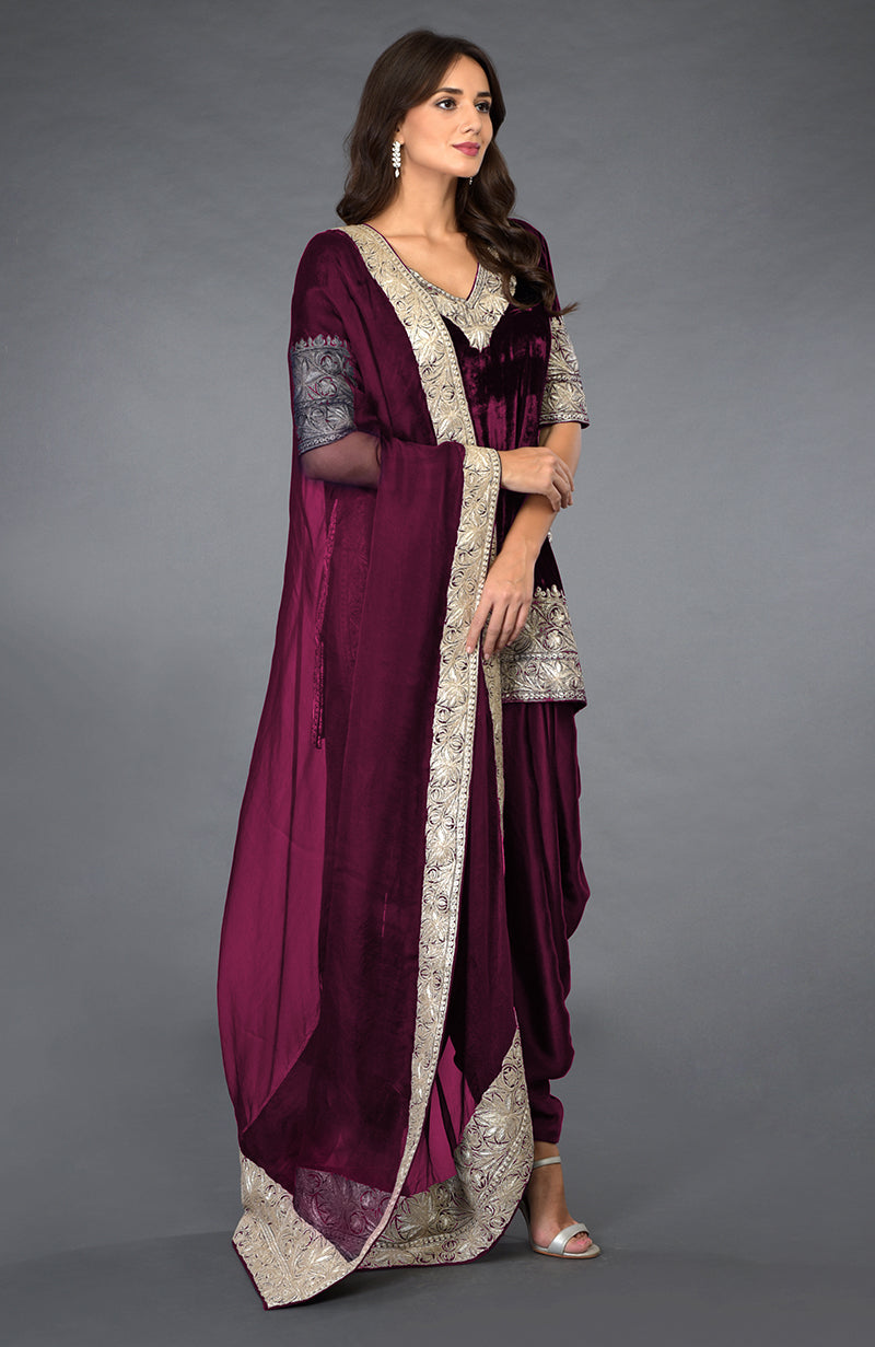 A woman models a burgundy velvet dhoti pants suit with silver tilla embroidery.