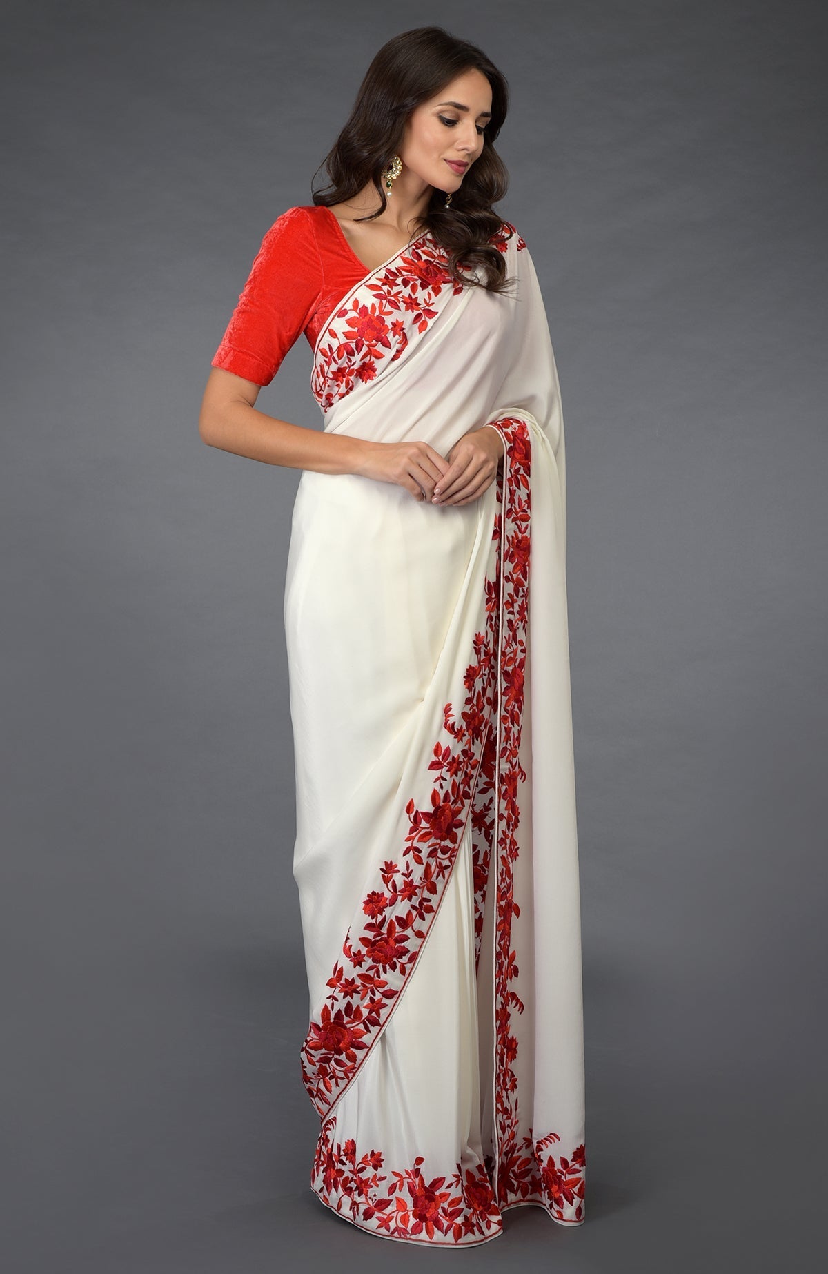 An ivory-red Parsi Gara hand-embroidered saree with a red velvet blouse.