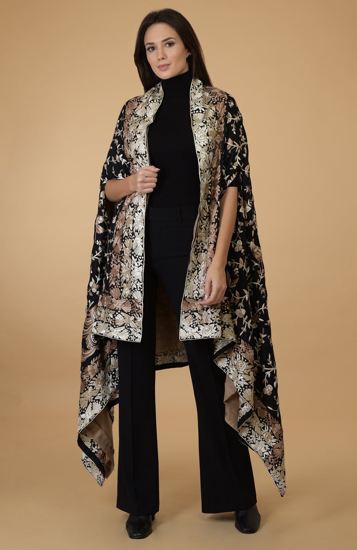 A woman models a black and beige Parsi Gara pure pashmina shawl cape.