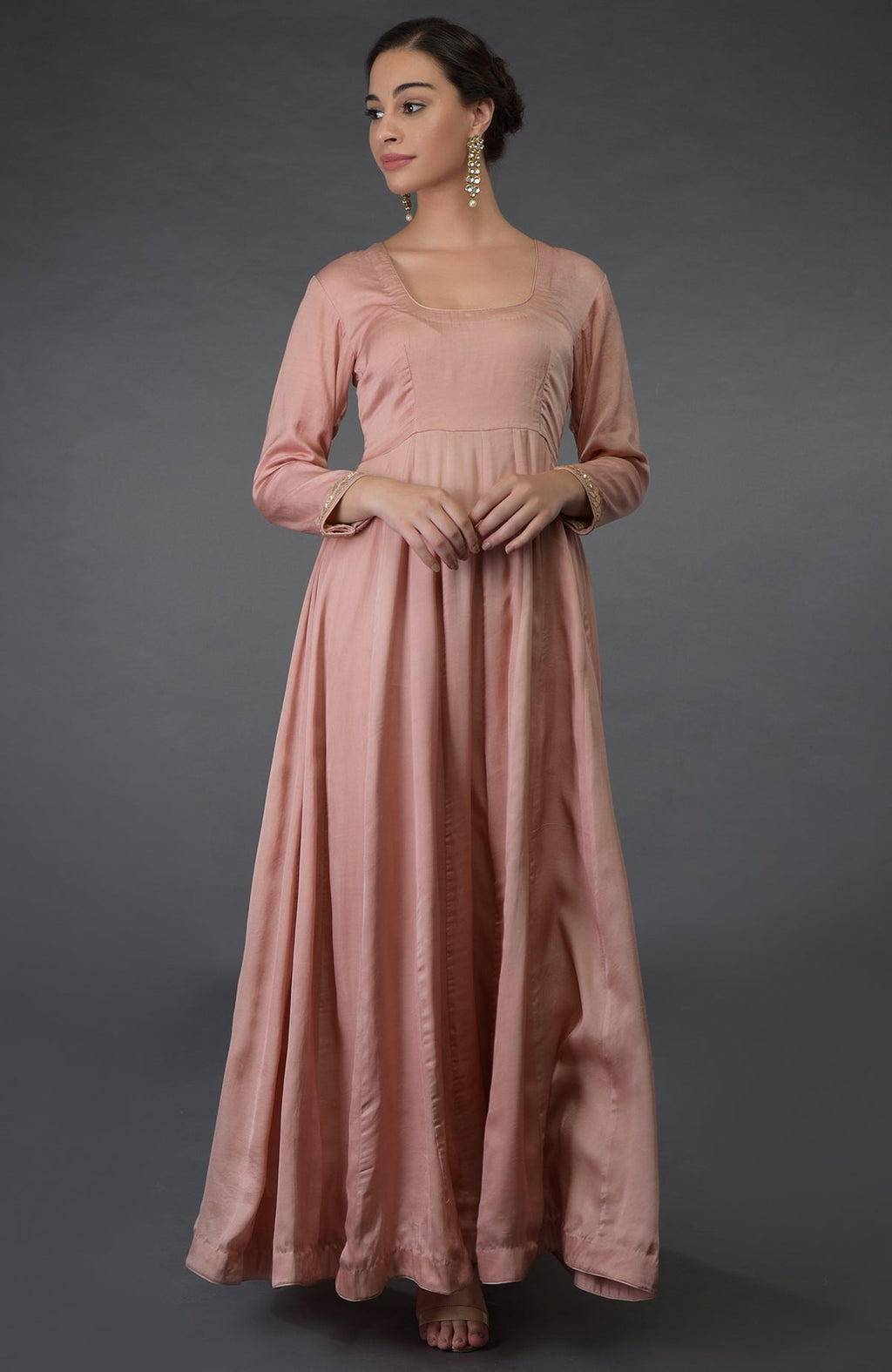A woman models a pressed rose gota patti and zardozi hand-embroidered suit.