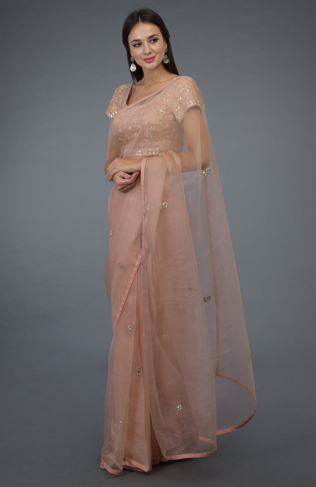 A woman models a pressed rose zardozi gota patti embroidered saree and blouse.