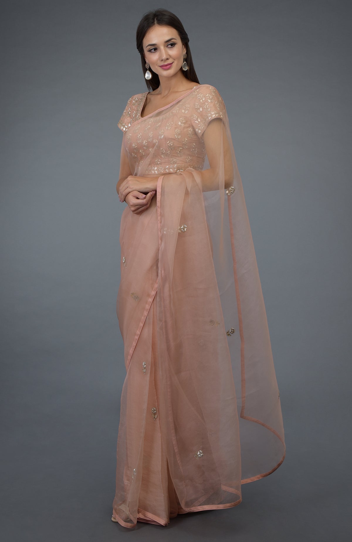 A woman models a pressed rose zardozi gota patti embroidered saree and blouse.